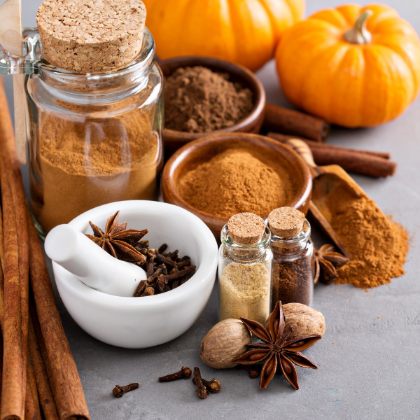 Homemade pumpkin pie spice blend in a glass jar with cinnamon sticks — a hormone-supporting fall recipe